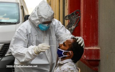 ممرض بحريني يأخذ عينة فحص فيروس كورونا المستجد قرب مجمع سكني لعمالة وافدة