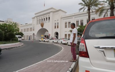 بحريني صاحب سيارة أجرة يقف بجانب المعلم التاريخي  باب البحرين في الحي التجاري في العاصمة المنامة